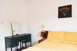 Schlafzimmer mit einem Bett, einem Spiegel und einem Schreibtisch in der Unterkunft Clee Ness - 1 bed maisonette, on the seafront in Cleethorpes