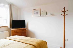 una camera con letto e TV su un comò di Clee Ness - 1 bed maisonette, on the seafront a Cleethorpes