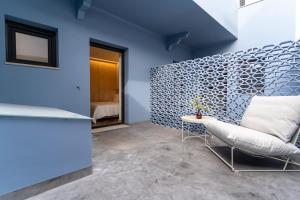 um quarto com paredes azuis e uma cadeira e uma mesa em CASA 3 - OS LUGARES DE CASTRALEUCA em Castelo Branco