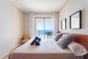 Un dormitorio con una cama con un osito de peluche. en Paradero Rental S74 - Vistas al Mar, en Calpe