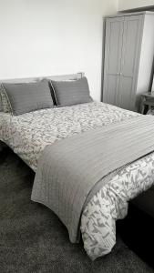 a bedroom with a large bed with a gray headboard at Modern 2 Bed House in Rainham, Kent - Central Location in Rainham