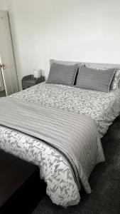 a large bed in a bedroom with a white bedspread at Modern 2 Bed House in Rainham, Kent - Central Location in Rainham