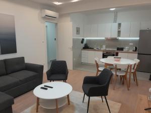 ein Wohnzimmer mit einer Couch und einem Tisch und Stühlen in der Unterkunft Olive center apartment in Trebinje