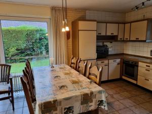 a kitchen with a table and chairs and a window at Vakantiehuis Ome Wim op 't Hoogelandt in De Koog