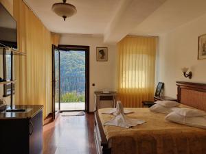 a bedroom with a large bed and a large window at Pensiunea TV Condor in Sinaia