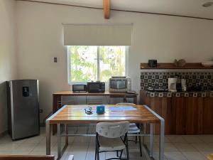 a kitchen with a wooden table and a refrigerator at Puesta del Sol in Quepos