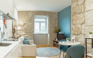 een keuken en een woonkamer met een tafel en stoelen bij Oporto Pool Apartment by Vacationy in Porto