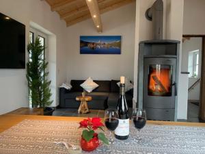 una sala de estar con chimenea y una mesa con copas de vino. en Allgäu-Chalet Kaufbeuren en Kaufbeuren