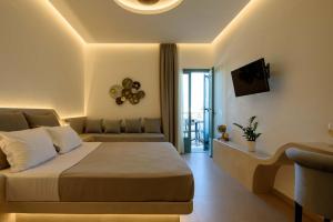 una camera d'albergo con letto e divano di Armonia a Kamari