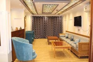 vestíbulo con sofá, sillas y mesa en Al-Mwadda Hotel en Seeb