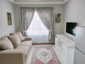 sala de estar con sofá y ventana en Sunrise Guesthouse en Pretoria