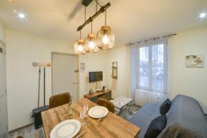- un salon avec une table et un canapé bleu dans l'établissement Appart Bambou rdc - parking gratuit- Netflix, à Bourges