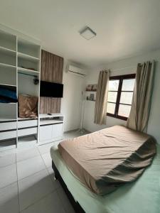 een slaapkamer met een groot bed en een raam bij GRAVATÁ WINTERVILLE FLAT 707 in Gravatá