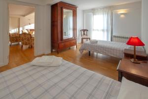 a bedroom with a bed and a table with a lamp at Casa junto a Reserva del Saja, bosque y montaña in Arenas de Iguña
