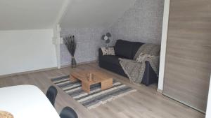 salon z czarną kanapą i stolikiem kawowym w obiekcie Le Gîte du Val de Noye w mieście Ailly-sur-Noye
