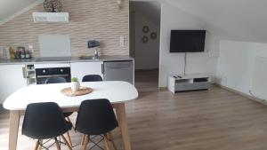 salon ze stołem, krzesłami i telewizorem w obiekcie Le Gîte du Val de Noye w mieście Ailly-sur-Noye