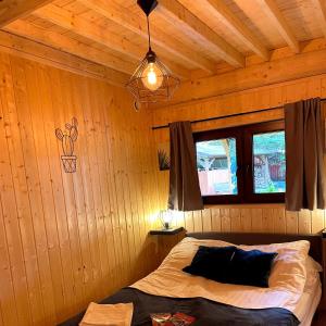 ein Schlafzimmer mit einem Bett in einem Holzzimmer in der Unterkunft Woda i Las in Jeżewo