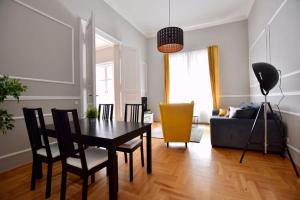 ein Wohnzimmer mit einem Tisch, Stühlen und einem Sofa in der Unterkunft Amazing APT in Central Cozy & Big Oktogon Andrassy in Budapest