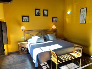 Hotel El Quintanal في Bode: غرفة نوم بسرير كبير وبجدران صفراء