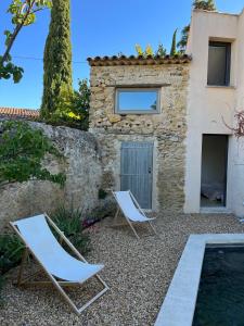 two lounge chairs and a house with a swimming pool at My Home in lourmarin in Lourmarin