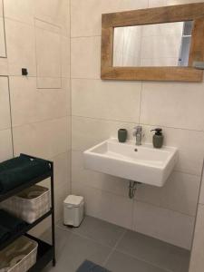 ein Badezimmer mit einem weißen Waschbecken und einem Spiegel in der Unterkunft Komfortný apartmán A407 v centre NR, bez kuchyne, parkovisko zdarma in Nitra