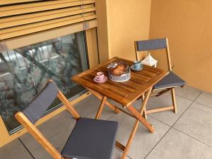 una mesa de madera con una cesta de comida y una silla en Komfortný apartmán A407 v centre NR, bez kuchyne, parkovisko zdarma, en Nitra