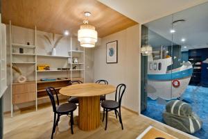 Apartament Zatoka 12 في بوك: غرفة طعام مع طاولة وجدارية قارب
