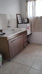 una cucina con lavandino e frigorifero di El três a Chuy