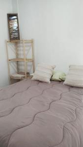 ein Bett mit zwei Kissen auf einem Zimmer in der Unterkunft El três in Chuy