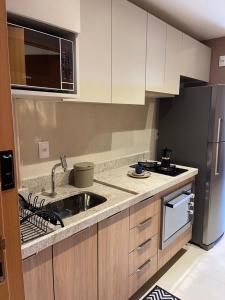 a kitchen with a sink and a microwave at Flat novo no Eco Resort in Tamandaré