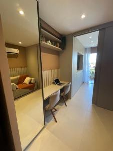 Zimmer mit einem Tisch, einem Bett und einem Spiegel in der Unterkunft Flat novo no Eco Resort in Tamandaré