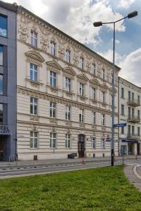 duży biały budynek na ulicy z światłem ulicznym w obiekcie Apartament z jacuzzi w Krakowie