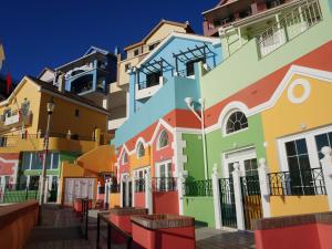 a row of colorful houses in a street at Unique Waterfront Duplex on the Mediterranean - Caleta, Catalan Bay in Gibraltar