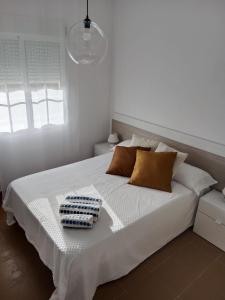 a white bed with two towels on top of it at Albatros Golf Costa Esuri Ayamonte Huelva in Huelva