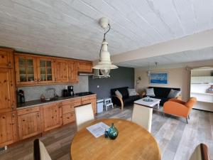 a kitchen and living room with a wooden table at Westzicht in Den Burg