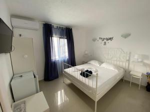 a white bedroom with a white bed and a window at Vila Fifi Costinesti in Costinesti