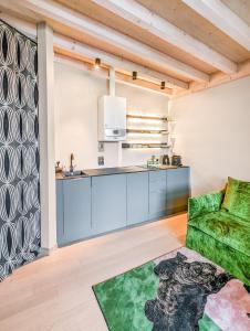 eine Küche mit blauen Schränken und einer grünen Couch in der Unterkunft Lemonhouse Bezzuglio in Toscolano-Maderno