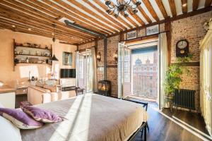 a bedroom with a large bed and a living room at 1851: Exceptional 19th century studio in Madrid in Madrid