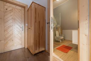 uma casa de banho com um WC e uma porta de madeira em Sielanka w górach em Gliczarów Górny