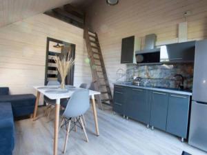 a kitchen with blue cabinets and a table and chairs at Fiszka in Mrzeżyno