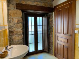 a bathroom with a sink and a large window at Hotel El Quintanal in Bode