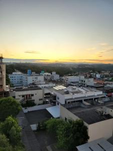 Blick auf eine Stadt bei Sonnenuntergang mit Gebäuden in der Unterkunft Apartamento centro Efapi ideal para trabalho ou estudo in Chapecó