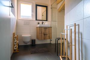 a bathroom with a toilet and a sink and a window at Chuenislodge3 neu&stilvoll, 2Balkone, echtes Bijou mit top-Aussicht in Adelboden