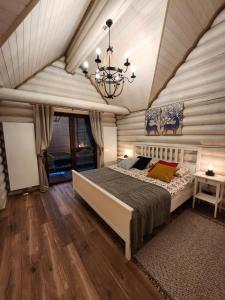 um quarto com uma cama grande e um lustre em JELONKOWO - Dom na wynajem - Kaszuby em JeleÅ„ska Huta