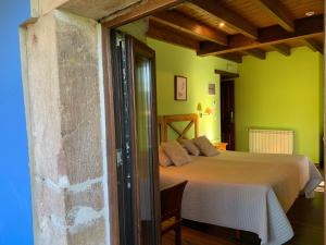 a bedroom with a bed in a room with green walls at Hotel El Quintanal in Bode