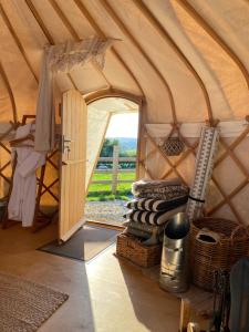 een kamer in een yurt met een open deur bij The Yurt @ Osmore in Axminster