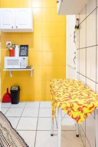uma cozinha com uma mesa e uma parede amarela em Hotel Mama! Copacabana (Posto1 -Leme) no Rio de Janeiro
