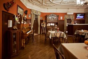 a restaurant with tables and a piano in a room at Old Vienna in Saint Petersburg