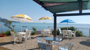 un gruppo di sedie, tavoli e ombrelloni su una spiaggia di Tenda a Tertenìa