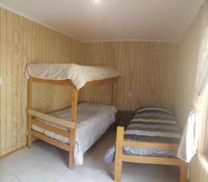 Cette petite chambre comprend des lits superposés et une chaise. dans l'établissement Trinares de Olmue, à Granizo